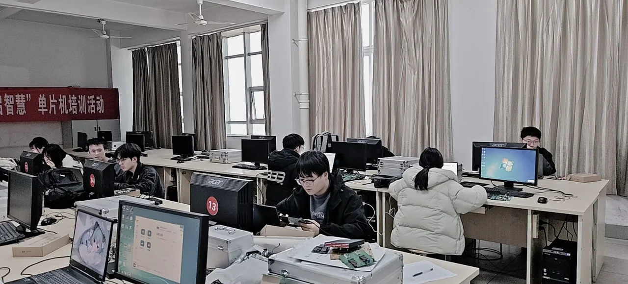 电子爱好者协会单片机培训现场，同学们在实验室使用电脑和开发板实践